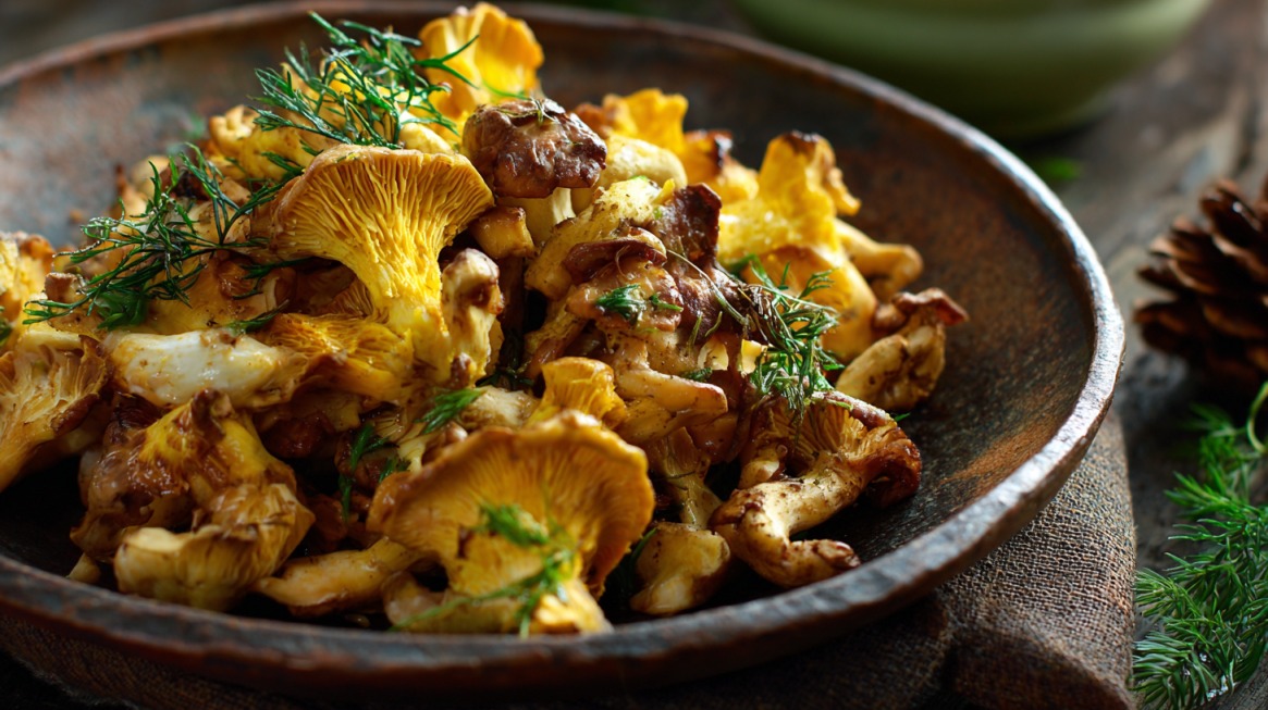 Close-up of sautéed Chicken of the Woods mushrooms in a rustic bowl, garnished with fresh herbs, showcasing their golden color and hearty texture