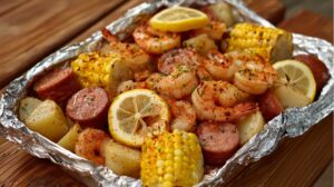 Foil pack filled with shrimp, sausage, corn on the cob, potatoes, and lemon slices, seasoned with Cajun spices