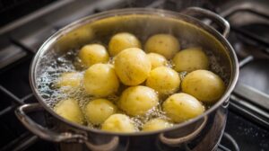 Pot of parboiled potatoes cooking in boiling water on a stovetop
