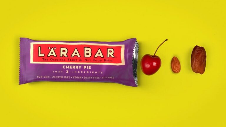 Larabars Cherry Pie bar on a yellow background with its three ingredients