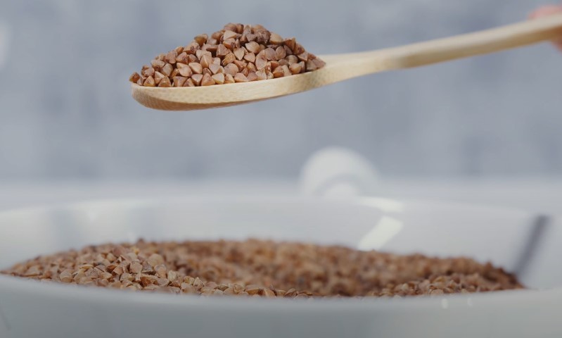A spoonful of onyx sorghum is being stirred into a bowl