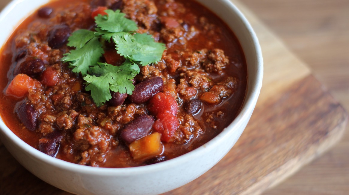 Bowl of chili with beans topped with fresh cilantro