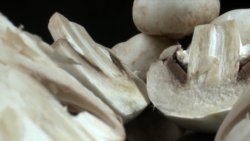 Frozen mushroom halves and slices displayed close up