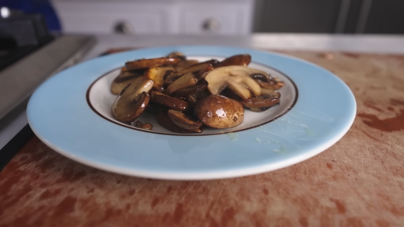 Cooked mushrooms rest on a plate to cool fully before freezing