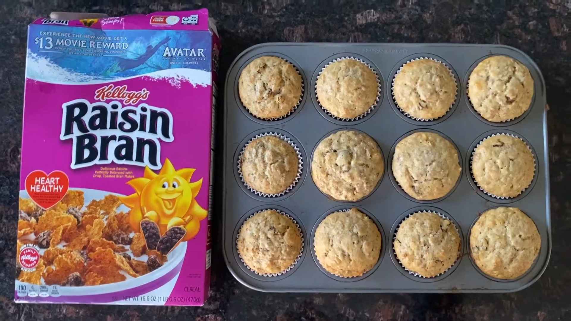 Box of Raisin Bran cereal beside a tray of homemade muffins