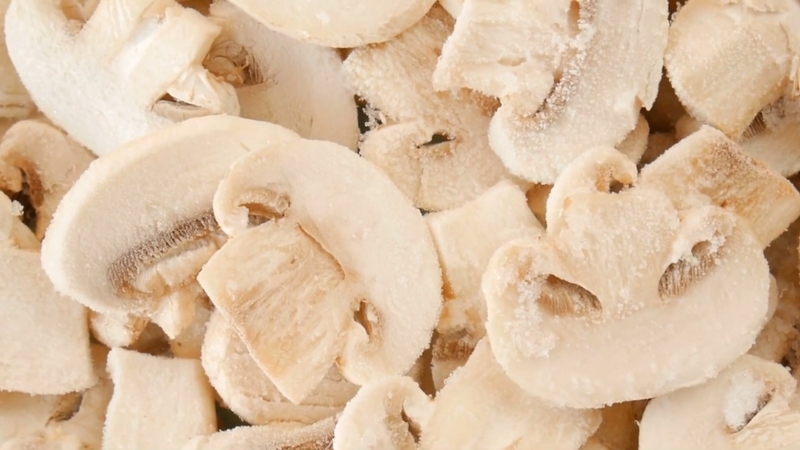 Frozen mushroom slices packed together before cooking